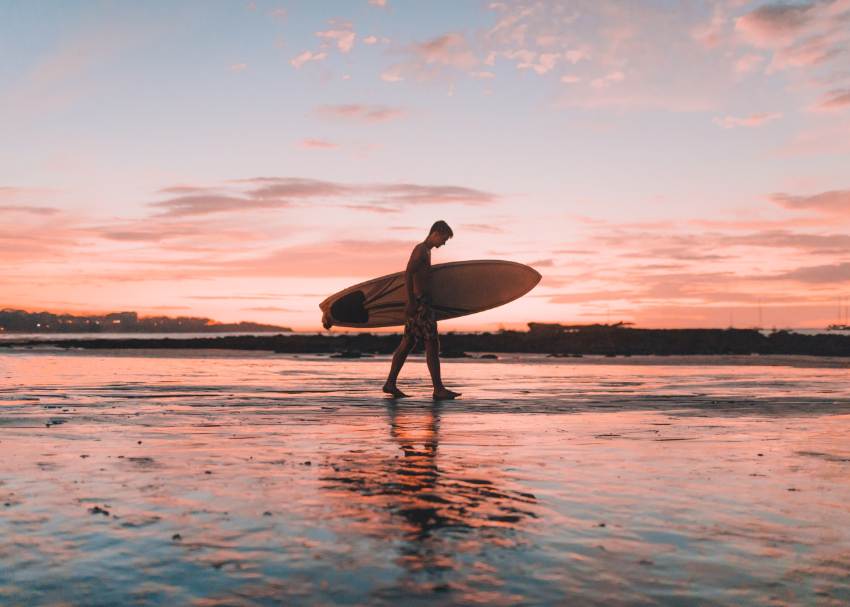 A man carrying a surfboard in Costa Rica